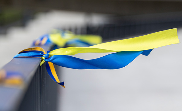 A blue and yellow ribbon is attached to a railing.