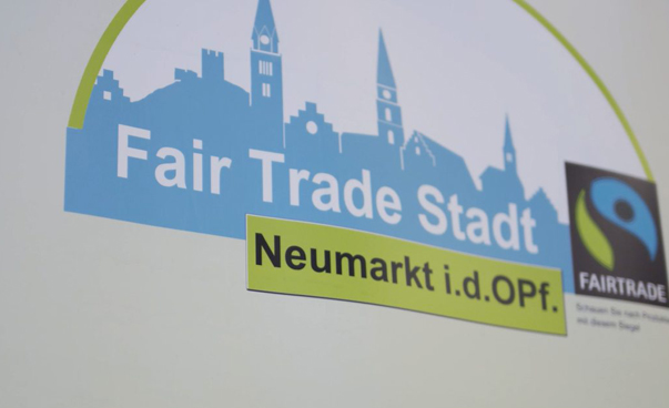 Ein Plakat mit dem Fairtrade-Logo sowie dem Text "Fair Trade Stadt" Neumarkt in der Oberpfalz ist zu sehen.