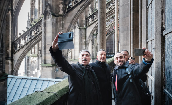 Vier Teilnehmer stehen außen am Kölner Dom und fotografieren.