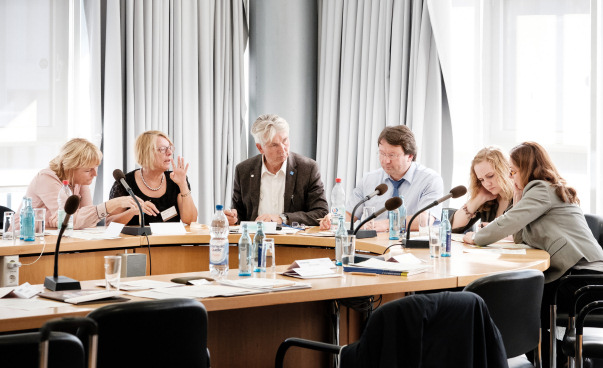 Sechs Menschen sitzten an einem Konferenztisch und unterhalten sich. Foto: Martin Magunia