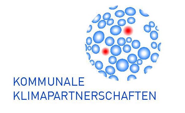 Eine blau gezeichnete Weltkugel mit zwei roten Markierungen; links davon stehen die Worte Kommunale Klimapartnerschaften.