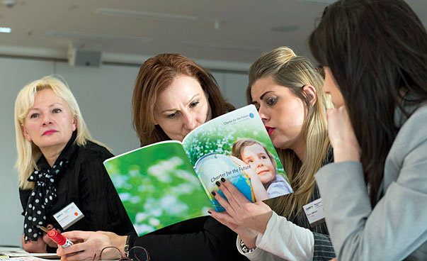 Participants of the workshop reading in a brochure.