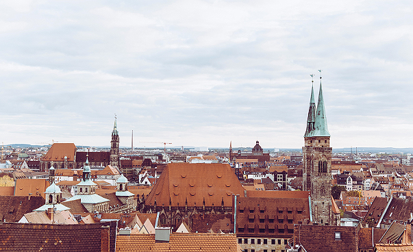 Blick über die Dächer der Stadt Nürnberg. Zu sehen sind Hausdächer und zwei Kirchtürme.