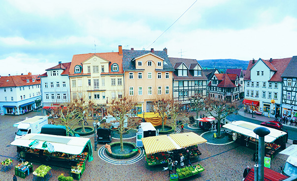 Ein Marktplatz mit Ständen, umsäumt von den Häusern der Stadt Witzenhausen.