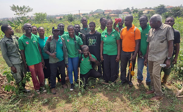 Circa ein Dutzend Personen, zumeist in grünen Shirts, posieren für ein Gruppenfoto.