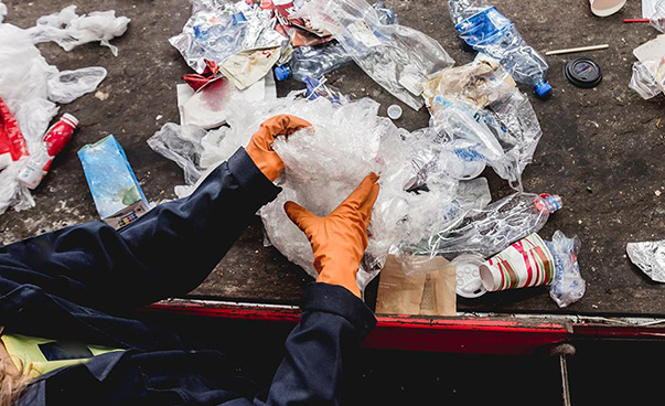 Eine Person sortiert Plastikmüll.