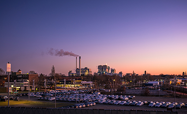 Fabrikschlote der Stadtneumünster blasen Rauch in den Abendhimmel.