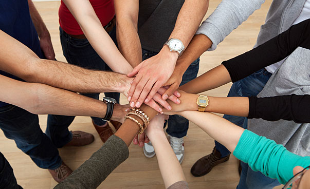 Die Hände vieler Menschen greifen einander in der Mitte zusammen. Foto: panthermedia.net_Andrey Popov