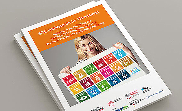 Ein Heft mit dem Titel „SDG-Indikatoren für Kommunen“ ist vor grauem Hintergrund abgebildet. Foto: Engagement Global