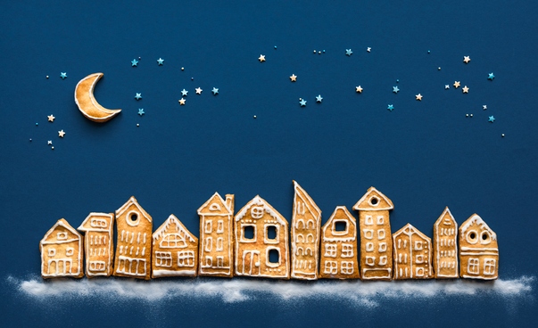 Eine Stadtsilhouette aus Lebkuchen vor einem dunkelblauen Hintergrund mit Sternen.