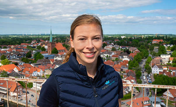 Portrait von Lina Koop, im Hintergrund ein Teil von Neustadt in Holstein aus der Vogelperspektive