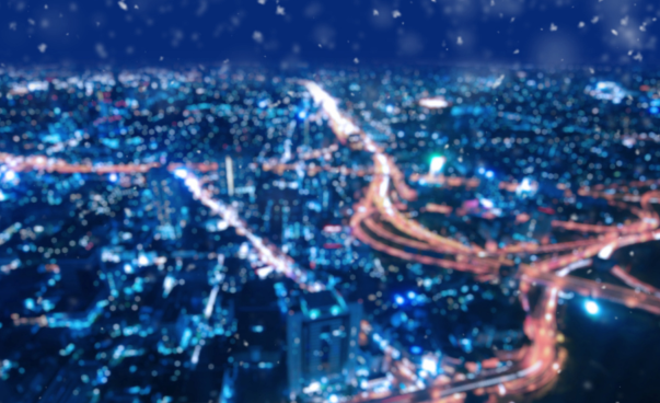 Eine Luftaufnahme einer Stadt bei Nacht bei Schneefall.