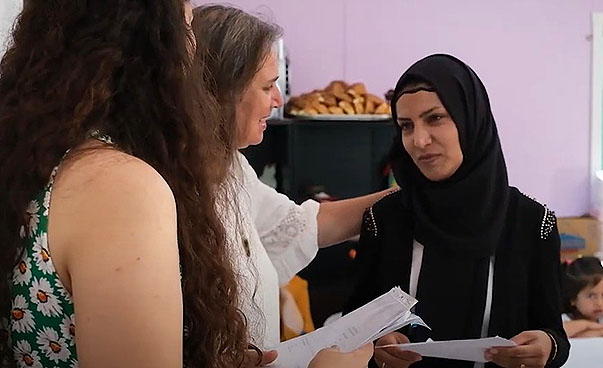 Screenshot aus dem Video über die Türkei. Drei Frauen mit Dokumenten in der Hand stehen zusammen und unterhalten sich.