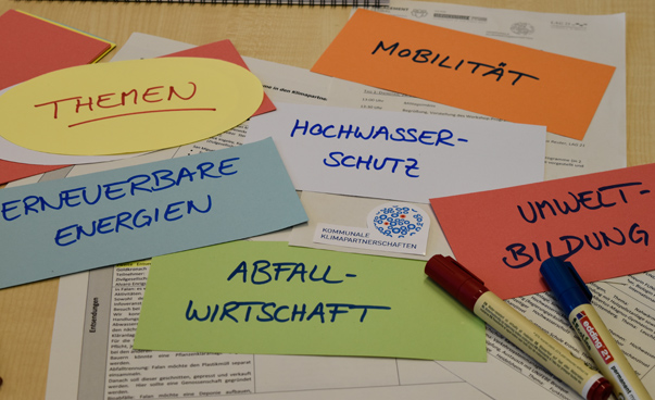 Viele bunte beschriebene Zettel und Stifte liegen auf einem Tisch. Foto: Engagament Global