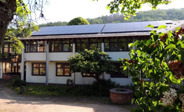 Auf dem Dach eines Gebäudes sind Solarmodule angebracht.