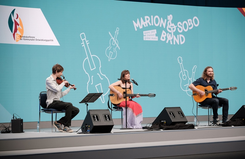 Die drei Mitglieder der Marion&Sobo Band sitzen auf der Bühne.