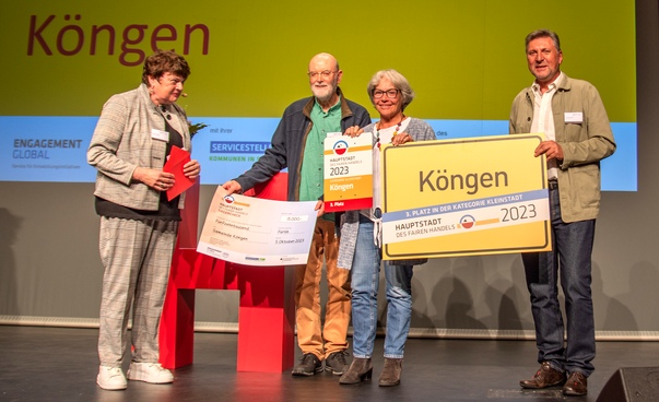 Die Delegation aus Köngen mit Ortsschild, Urkunde und Scheck beim Wettbewerb Hauptstadt des Fairen Handels.