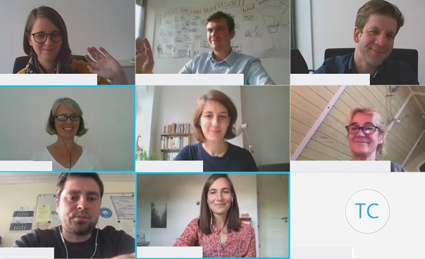 Screenshot einer Videokonferenz mit neun Feldern, auf denen jeweils eine Person zu sehen ist.