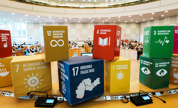 Verschiedene Würfel mit den SDG-Symbolen stehen auf einem Tisch.