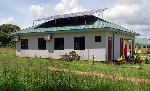 Das einstöckige Gebäude der Gesundheitseinrichtung mit Solarpanelen ist zu sehen.
