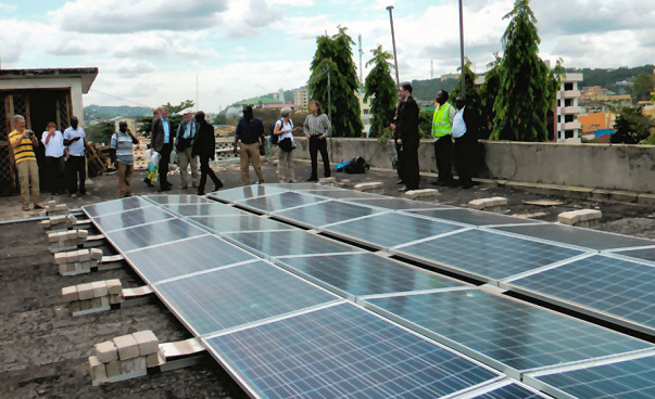 people on a rooftop looking at a photovoltaic plant