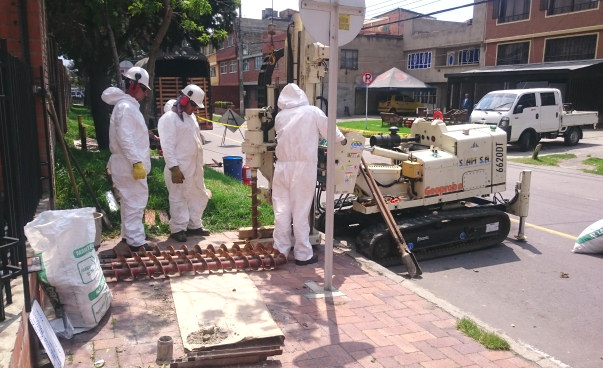 Drei Personen nehmen Bohrungen auf dem kontaminierten Areal in Bogotá vor