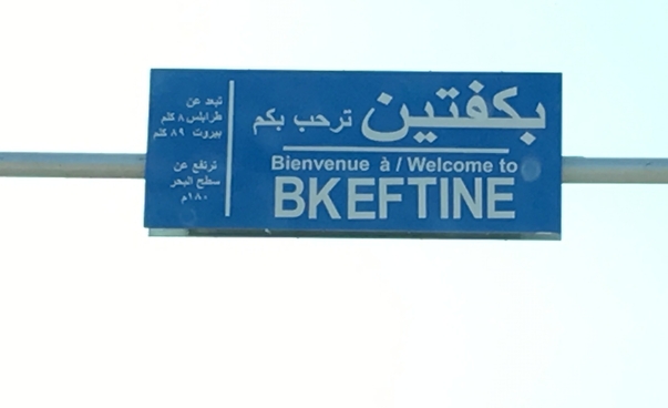 A road sign on the outskirts of Bkeftine against a blue sky.