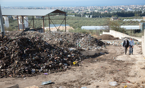 A makeshift landfill. Refugee shelters can be seen in the background.
