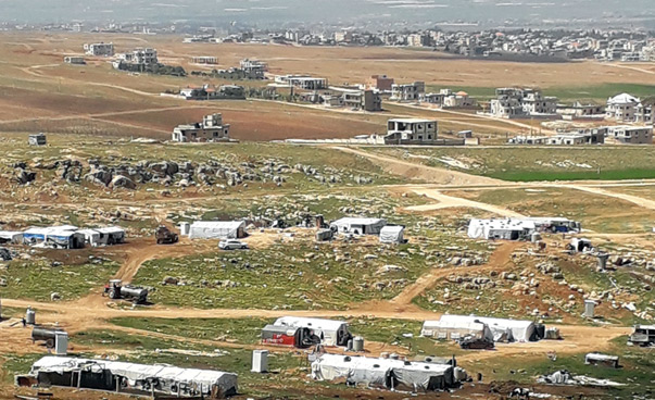 View of a valley with temporary accommodation for refugees.