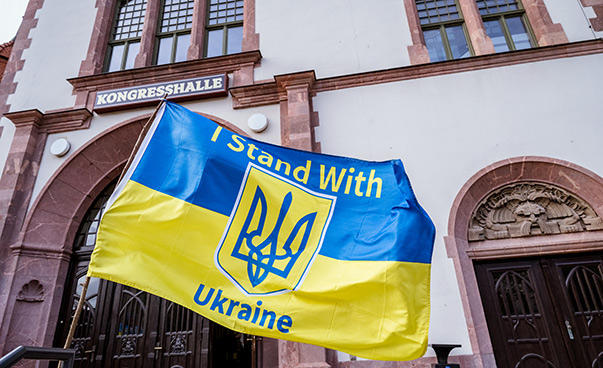 A blue and yellow flag bearing the words “I stand with Ukraine” flies outside the Kongresshalle am Zoo conference centre in Leipzig.
