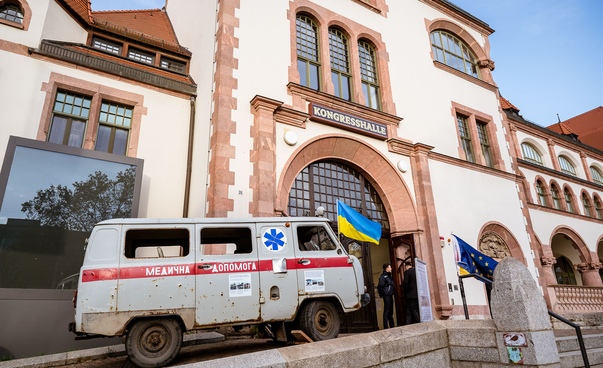 Ein ausrangierter ukrainischer Krankenwagen mit Einschusslöchern steht vor der Leipziger Kongresshalle am Zoo.