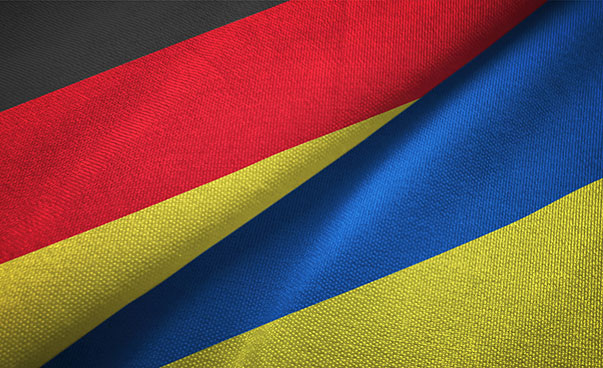 Eine deutsche und eine ukrainische Flagge liegen übereinander.