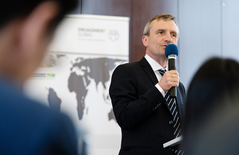 Thomas Geisel, Oberbürgermeister der Landeshauptstadt Düsseldorf, steht an einem Rednerpult und spricht in ein Mikrofon, das er in der rechten Hand hält.