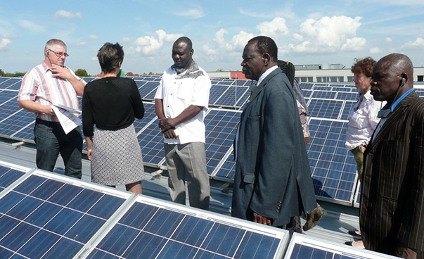 Eine Besuchergruppe besichtigt eine Photovoltaikanlage.