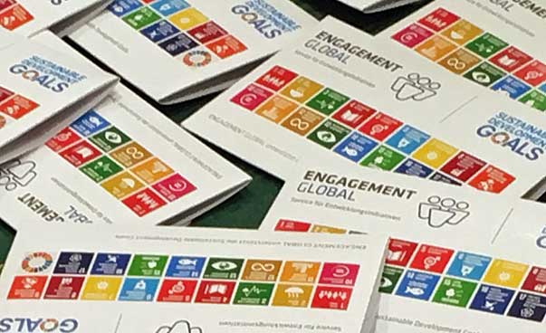 Blick auf einige ausgebreitete Heftchen mit den Symbolen der 17 nachhaltigen Entwicklungsziele.