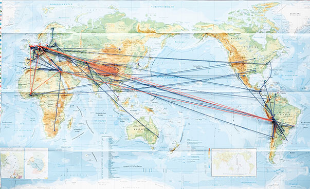 Blick auf eine Weltkarte. Einzelne Länder sind mit Fäden verbunden.