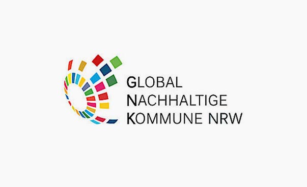 Das Logo mit dem Schriftzug Global Nachhaltige Kommune NRW ist zu sehen. Das Logo selbst besteht aus vielen bunten Rechtecken, die zusammen eine Art halbe Weltkugel bilden.