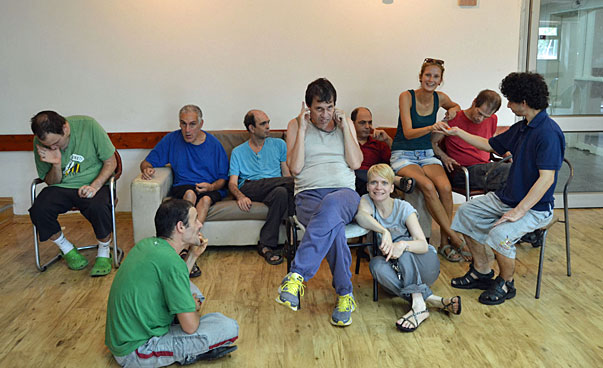 Eine Gruppe Menschen, einige mit körperlischen Einschränkungen, sitzen zusammen.