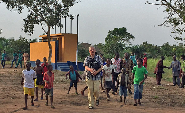 Kinder und ein Mann bewegen sich vor dem Hintergrund einer Sanitäranlage.