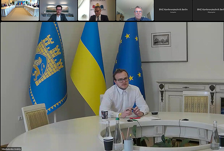 Andriy Moskalenko, stellvertretender Bürgermeister von Lviv, per Video hinzugeschaltet in einem Konferenzraum in Lviv. Im Hitnergrund die Flaggen der Ukraine und von Lviv.